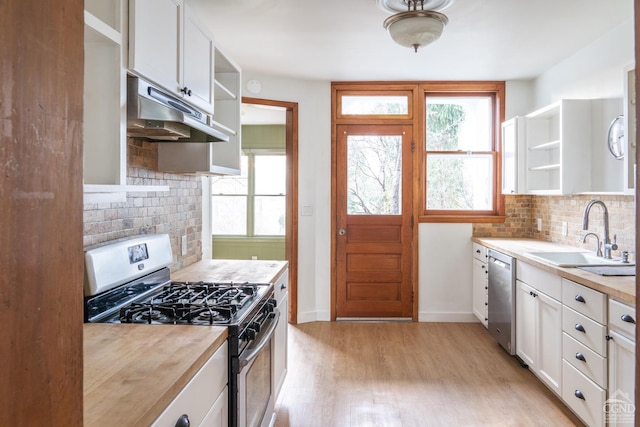 kitchen featuring wood counters, sink, light hardwood / wood-style floors, white cabinetry, and stainless steel appliances