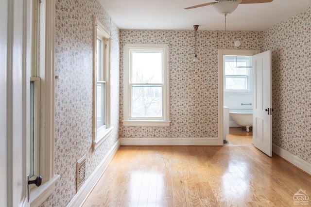 unfurnished bedroom with ceiling fan, light hardwood / wood-style flooring, and multiple windows