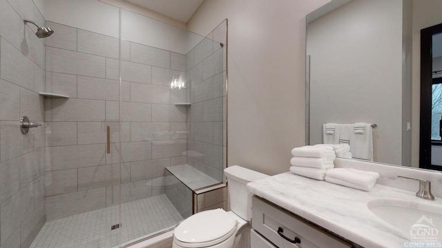 bathroom featuring vanity, toilet, and a shower with door