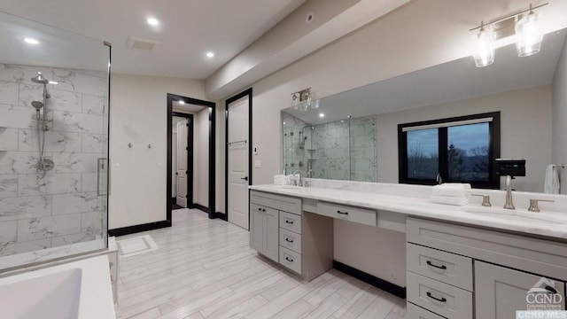 bathroom featuring a shower with door and vanity