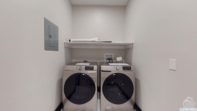 clothes washing area with washing machine and dryer and electric panel