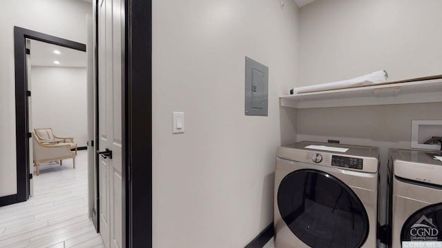 laundry room featuring electric panel, separate washer and dryer, and light hardwood / wood-style flooring