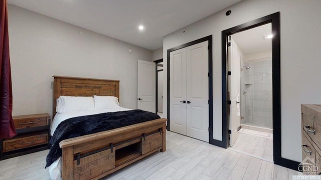 bedroom with connected bathroom, light hardwood / wood-style floors, and a closet