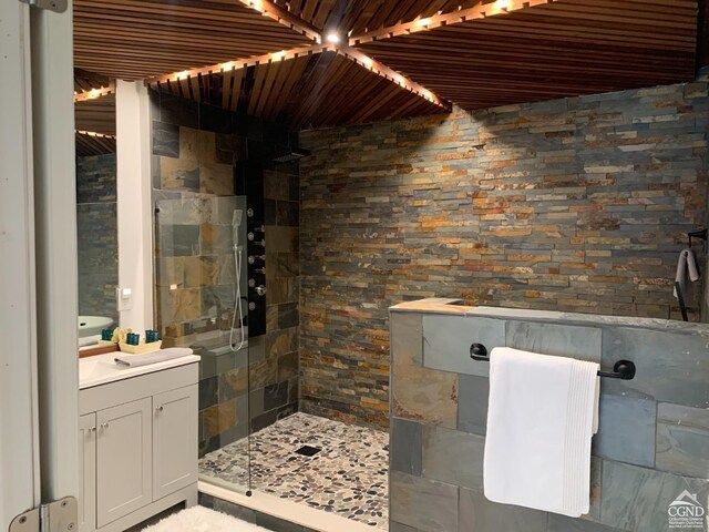 bathroom featuring vanity, a shower with door, and wood ceiling