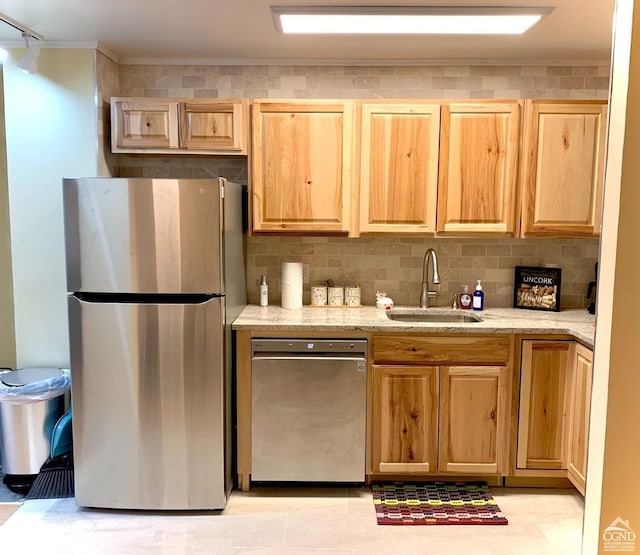 kitchen with backsplash, sink, stainless steel appliances, and light brown cabinetry