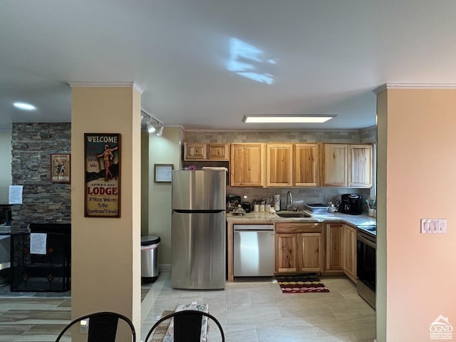 kitchen with track lighting, crown molding, sink, decorative backsplash, and appliances with stainless steel finishes