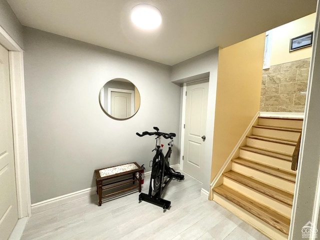 exercise room with light hardwood / wood-style floors