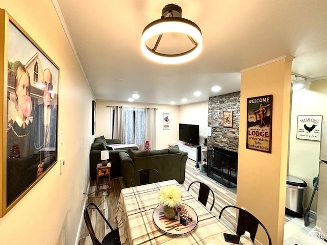 dining room featuring a fireplace and crown molding