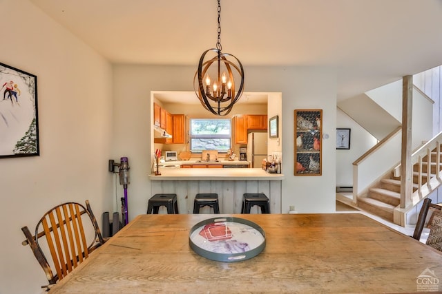 dining space featuring a chandelier, a baseboard radiator, and sink