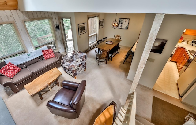 carpeted living room featuring wooden walls