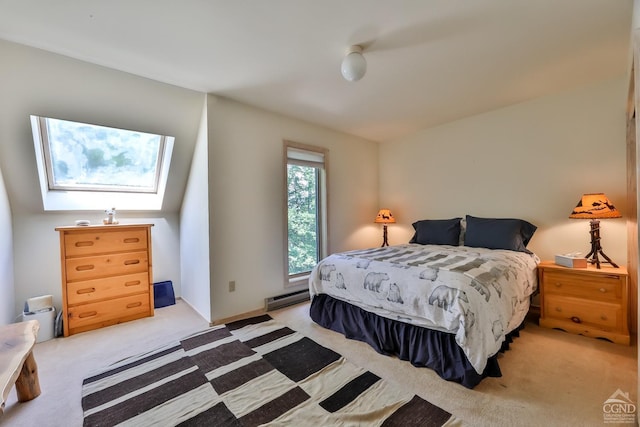 carpeted bedroom with a skylight and a baseboard heating unit