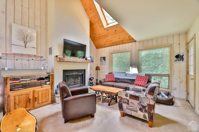 carpeted living room featuring wooden walls, wood ceiling, high vaulted ceiling, and a skylight