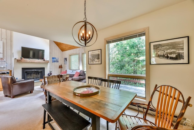 dining space with a notable chandelier, lofted ceiling, light carpet, and a baseboard heating unit