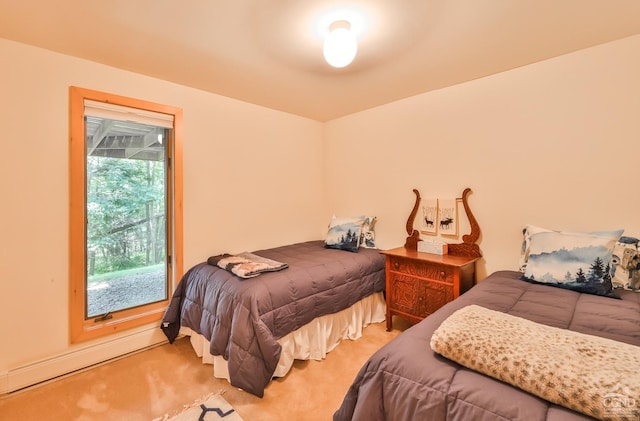 bedroom featuring light colored carpet and baseboard heating