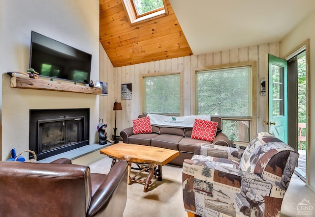 living room with lofted ceiling with skylight, plenty of natural light, and light colored carpet