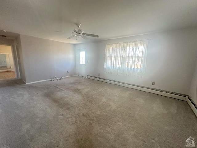 carpeted spare room with baseboards, ceiling fan, and a baseboard radiator