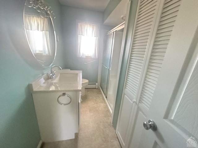 bathroom featuring toilet, a stall shower, a closet, vanity, and a baseboard radiator