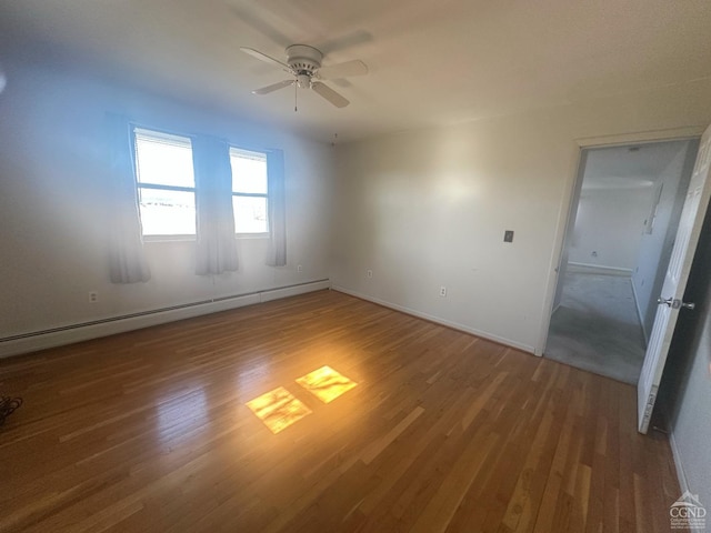 unfurnished room with a baseboard heating unit, wood finished floors, and a ceiling fan