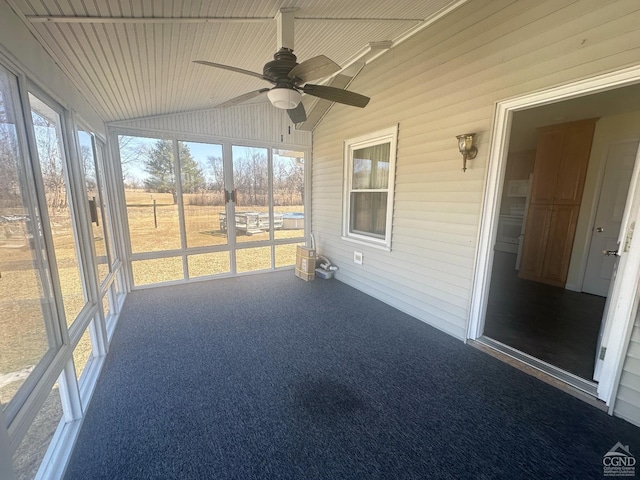 unfurnished sunroom featuring wood ceiling, ceiling fan, and vaulted ceiling