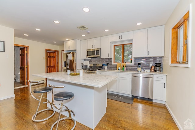 kitchen featuring white cabinetry, light hardwood / wood-style floors, and appliances with stainless steel finishes