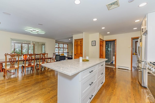 kitchen featuring a wealth of natural light, white cabinetry, a kitchen island, and stainless steel appliances