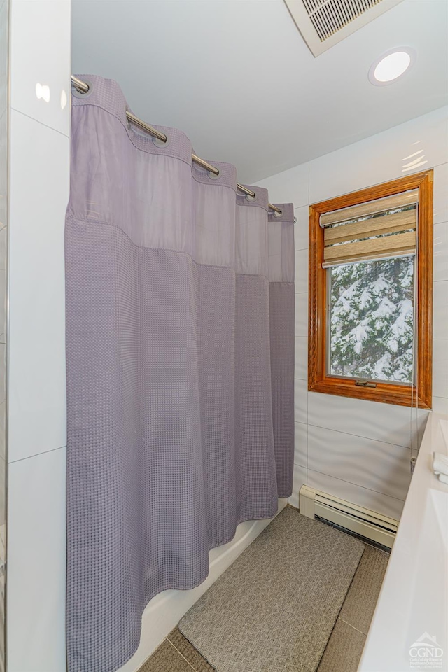 bathroom featuring tile patterned flooring, shower / tub combo with curtain, and baseboard heating