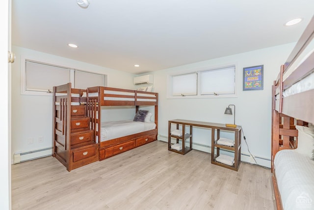 bedroom with light wood-type flooring, a wall unit AC, and a baseboard radiator