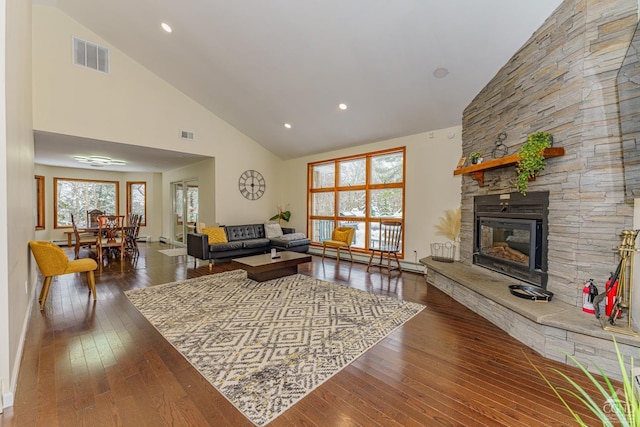 living room with high vaulted ceiling, dark hardwood / wood-style floors, a fireplace, and a wealth of natural light