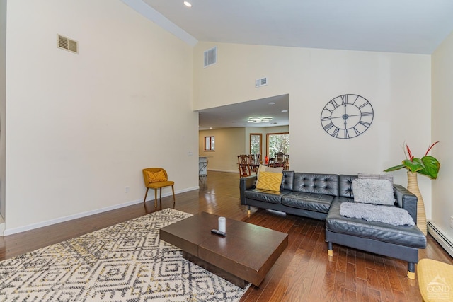 living room featuring baseboard heating, high vaulted ceiling, and wood-type flooring