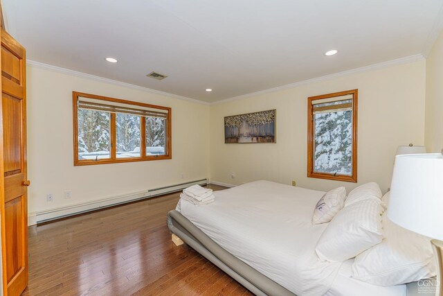 bedroom featuring ornamental molding, dark hardwood / wood-style floors, and a baseboard heating unit