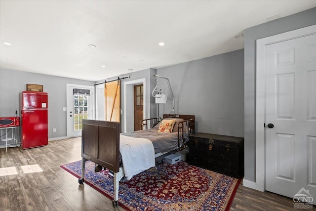 bedroom featuring a barn door and wood-type flooring