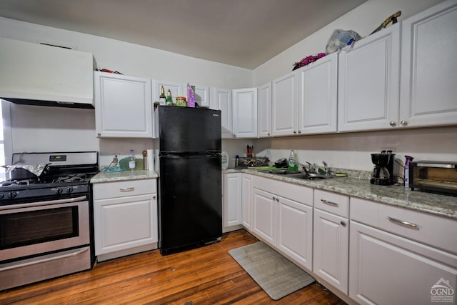 kitchen featuring stainless steel gas stove, sink, black fridge, dark hardwood / wood-style flooring, and white cabinets