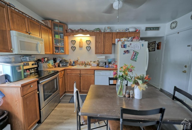 kitchen with white appliances, light hardwood / wood-style flooring, ceiling fan, and sink