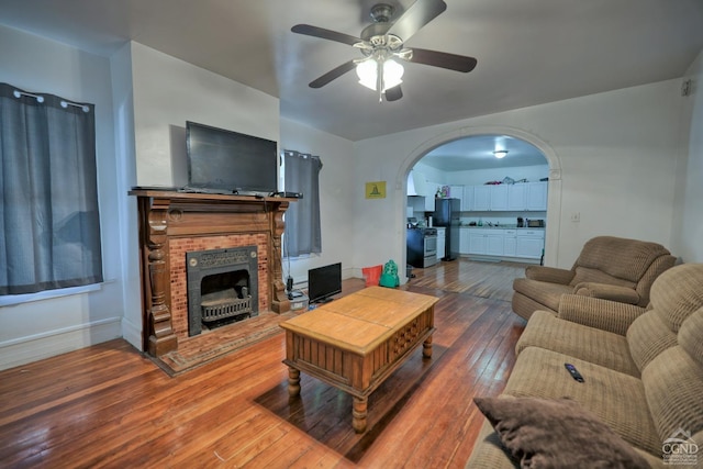 living room with a fireplace, hardwood / wood-style flooring, and ceiling fan