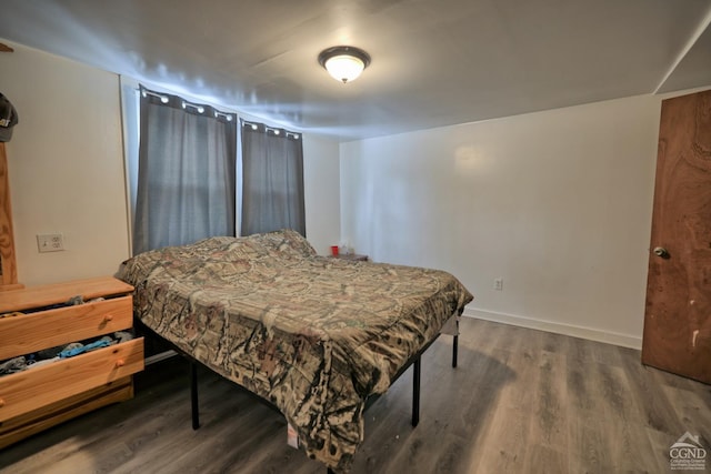 bedroom with dark wood-type flooring