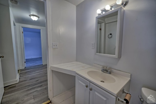 bathroom featuring vanity, wood-type flooring, and toilet