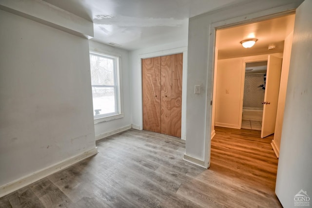 unfurnished bedroom featuring hardwood / wood-style flooring and a closet