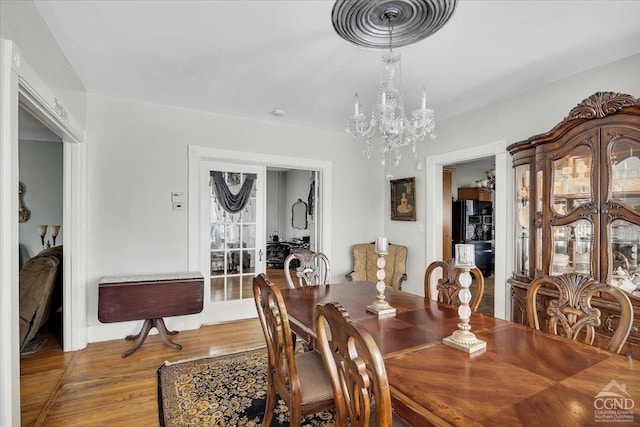 dining room featuring wood finished floors and a notable chandelier