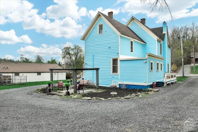 exterior space featuring an outdoor fire pit and a chimney