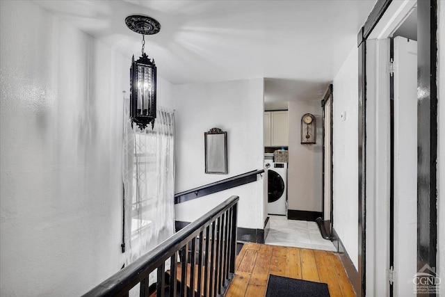 hallway with washer / clothes dryer and light wood finished floors
