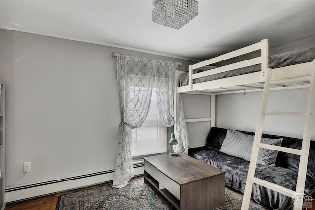 bedroom featuring wood finished floors and baseboard heating