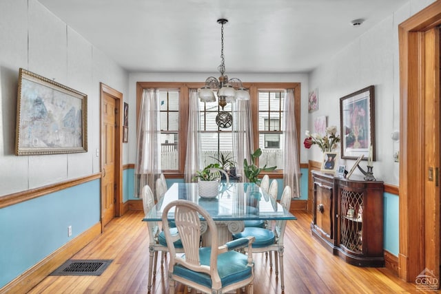 dining space with a chandelier and light hardwood / wood-style flooring