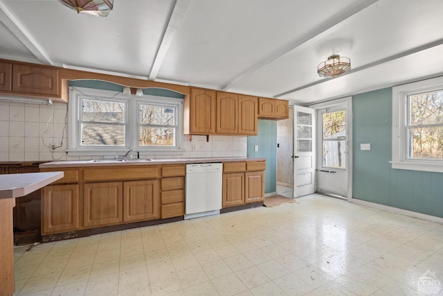 kitchen with light floors, backsplash, white dishwasher, and light countertops