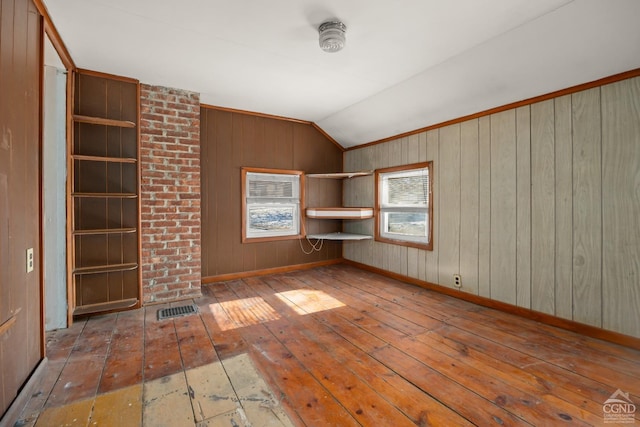 interior space with lofted ceiling, wood-type flooring, visible vents, and baseboards