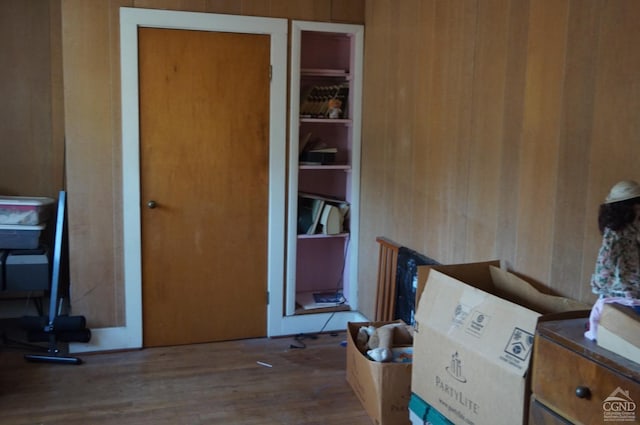 miscellaneous room with wood-type flooring and wooden walls