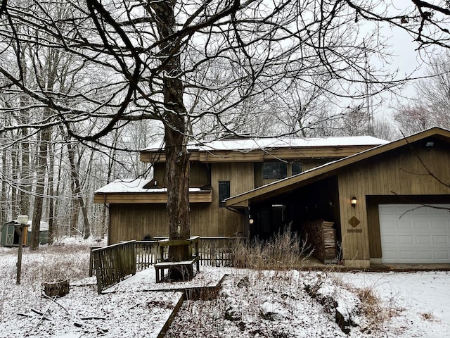 view of snowy exterior featuring a garage