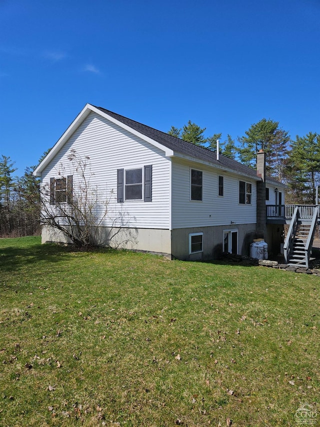 rear view of property with a lawn, stairway, and a deck