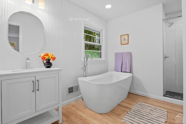 bathroom featuring vanity, wood-type flooring, and shower with separate bathtub