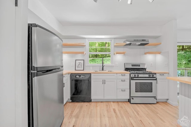 kitchen with appliances with stainless steel finishes, white cabinetry, a wealth of natural light, and sink