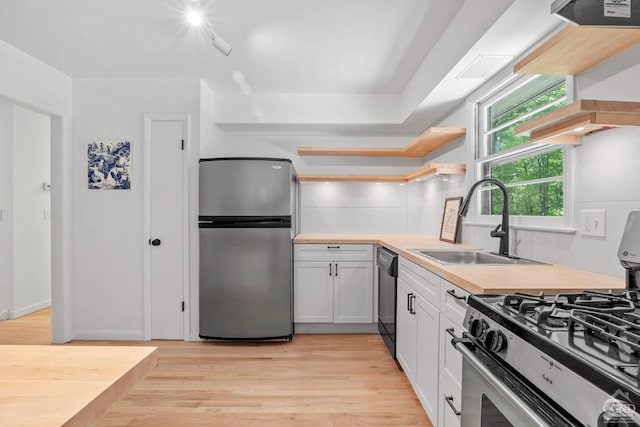 kitchen featuring sink, white cabinets, stainless steel appliances, and light hardwood / wood-style floors